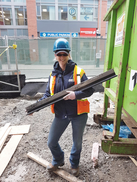 Erika Price holding a steel beam on a job site